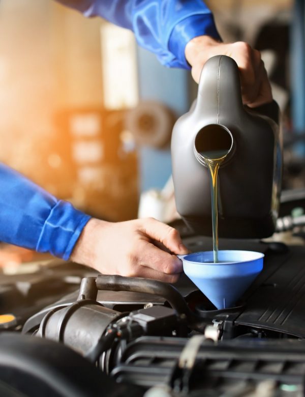 Male mechanic refilling car oil in service center Male mechanic refilling car oil in service center