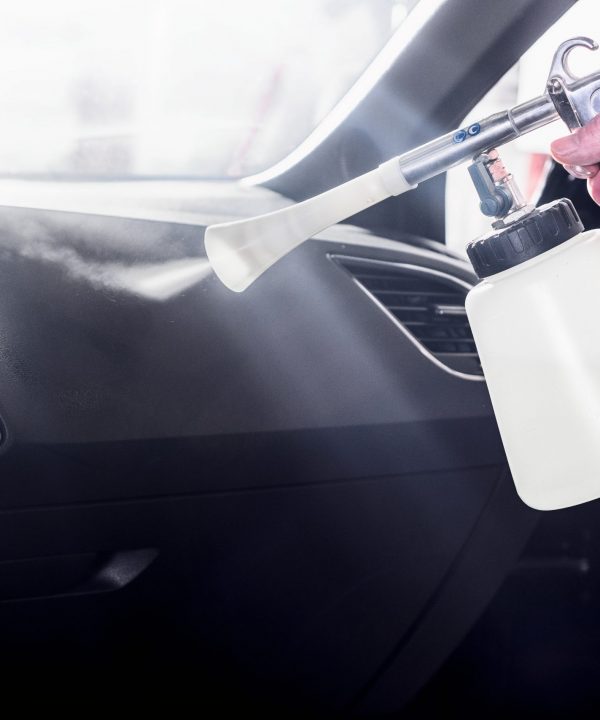 professionelle Autoreinigung in einer Werkstatt - Mann reinigt den Innenraum eines Fahrzeuges_professional car cleaning in a garage - man cleans the interior of a vehicle
